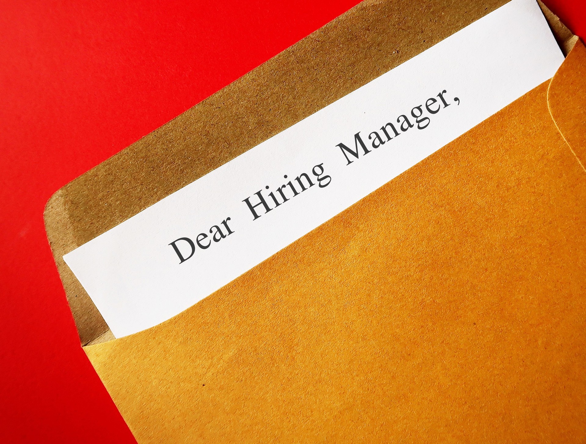 Office envelope with text written DEAR HIRING MANAGER, concept of writing cover letter to apply for job position recruitment